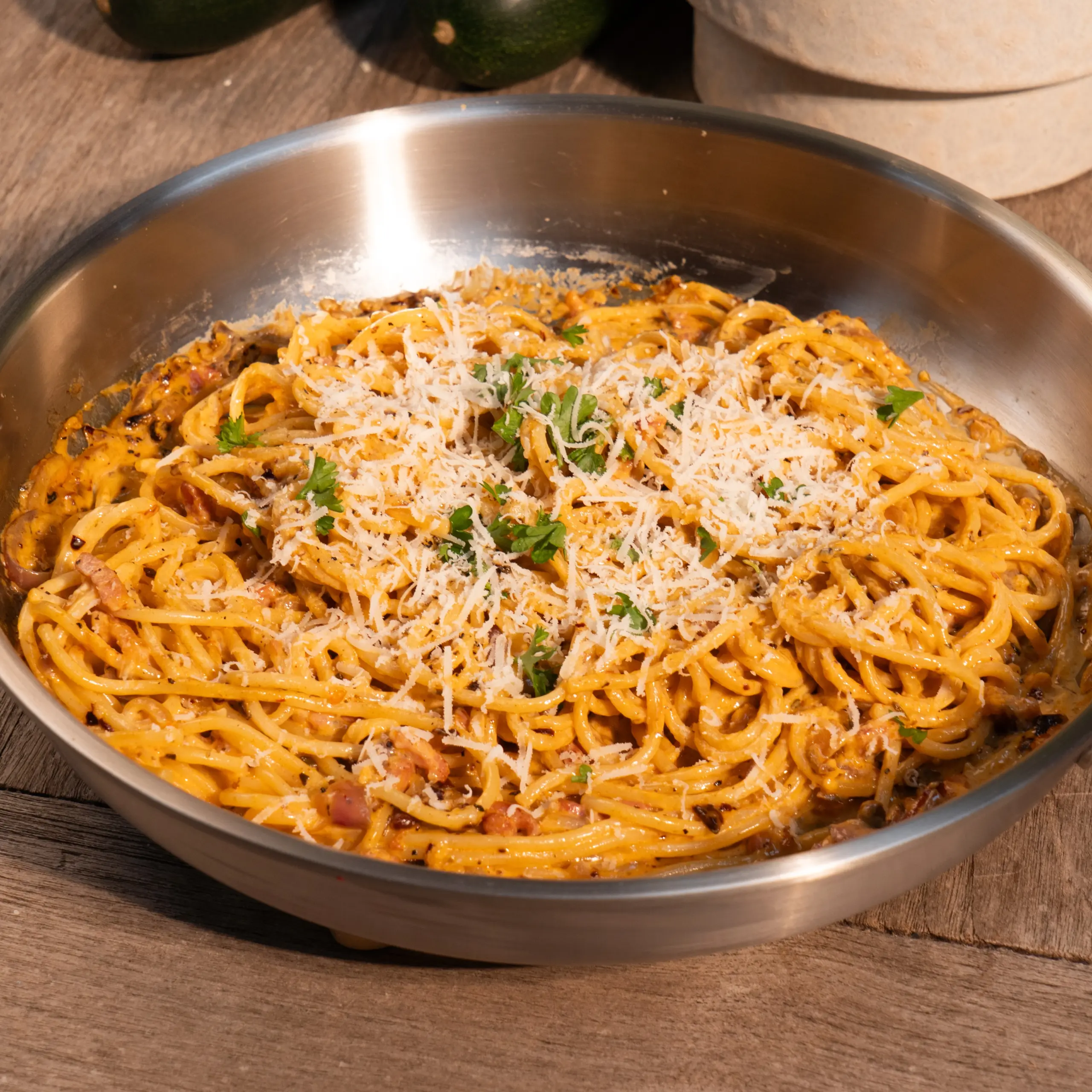 Romige spaghetti met spekjes, chili-olie en rode ui